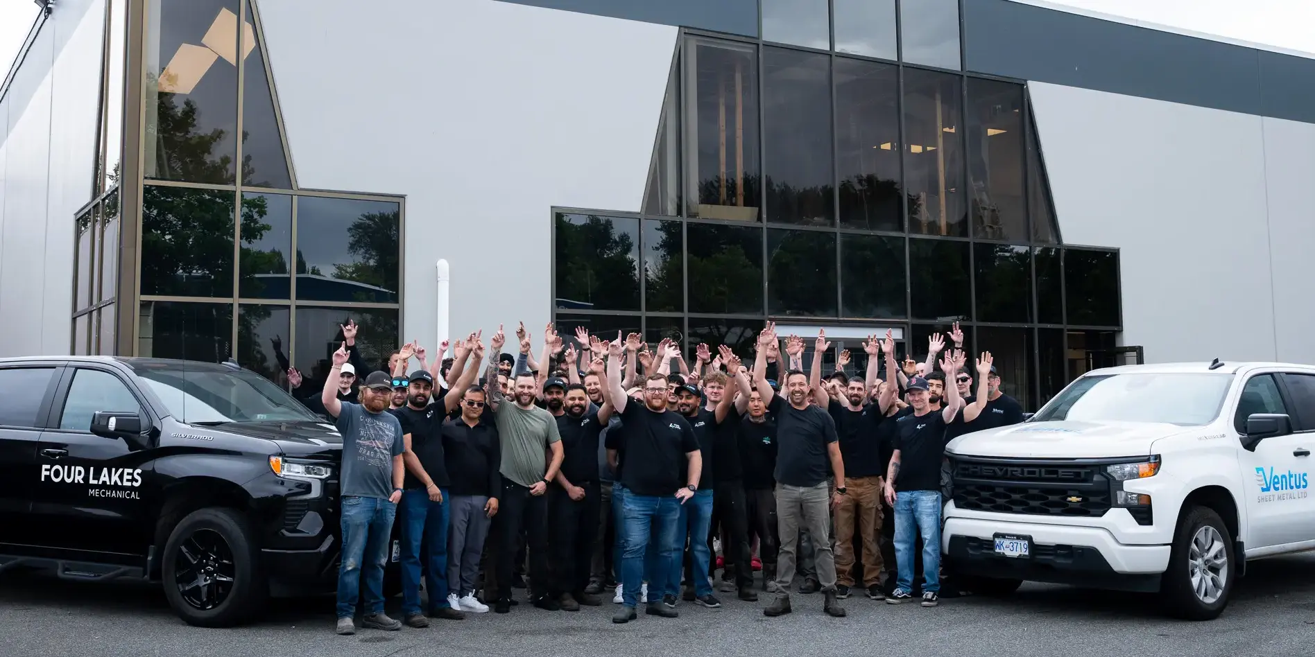 A team of employees with their hands up in the air